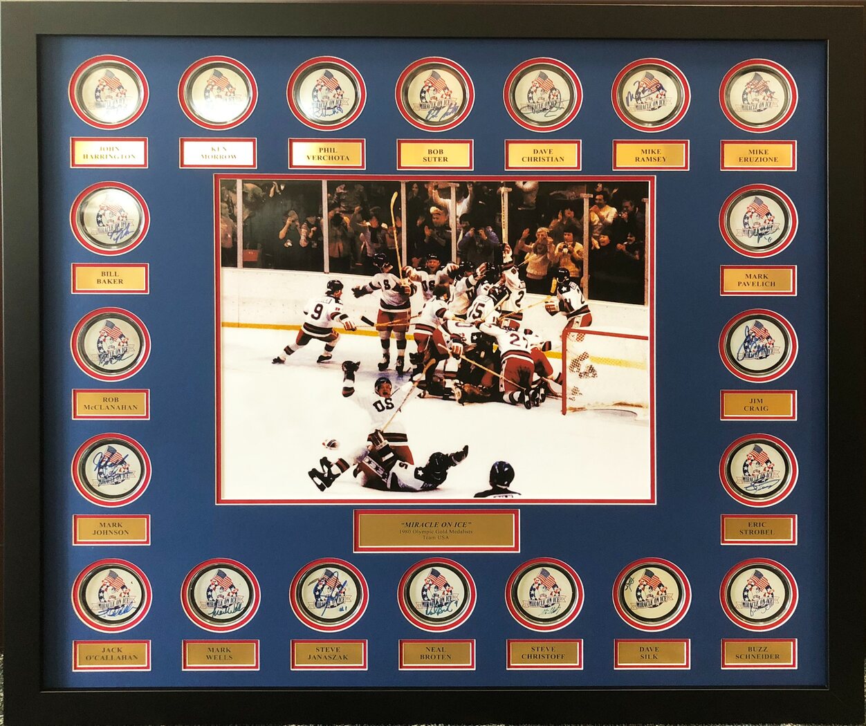Completed custom-framed Miracle on Ice display with signed commemorative pucks, player nameplates and team celebration photograph